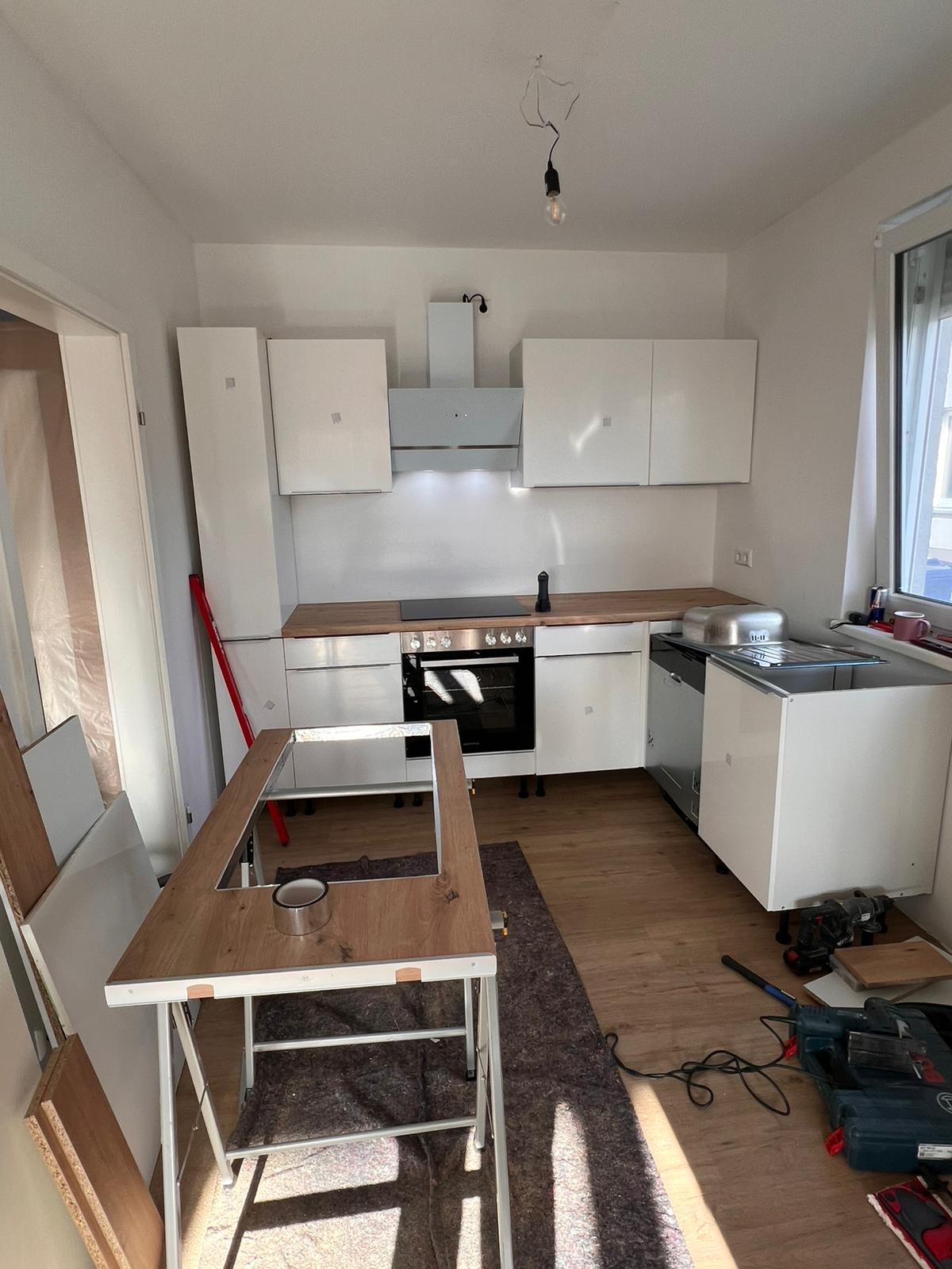 Professioneller Küchenaufbau einer weißen Einbauküche durch Ari Möbe